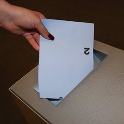 Einwerfen von Wahlzettel in Wahlurne